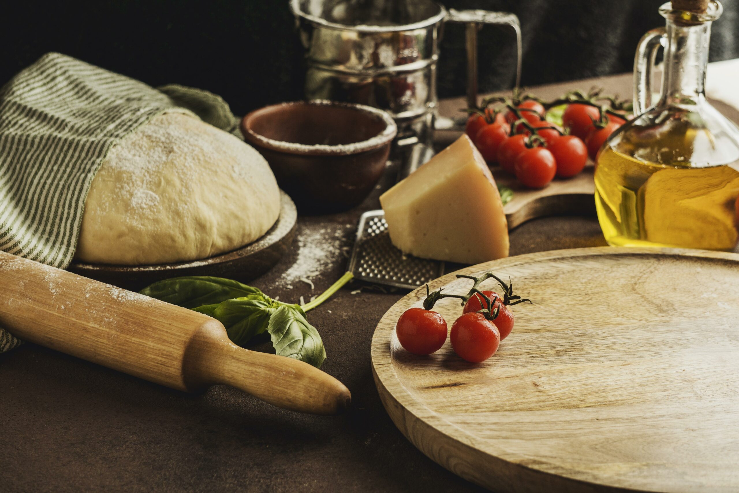 high-angle-pizza-dough-with-wooden-board-parmesan-cheese